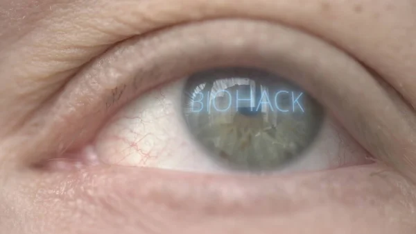 Texto BIOHACK brilhante no olho. Biohacking tiro macro relacionado — Fotografia de Stock