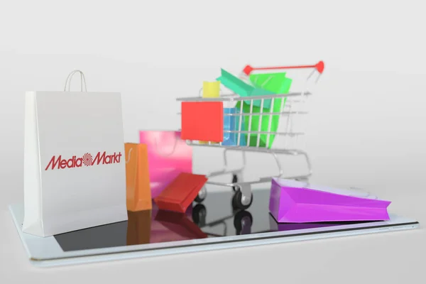 Belanja gerobak pada komputer tablet dan tas kertas dengan logo Media Markt. Editorial e-commerce terkait rendering 3D — Stok Foto