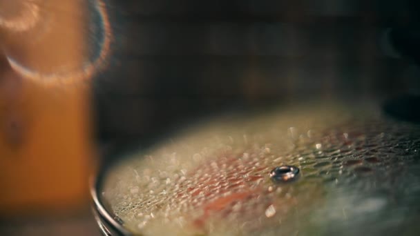 Water drops on glass cover of a frying pan — Stock Video