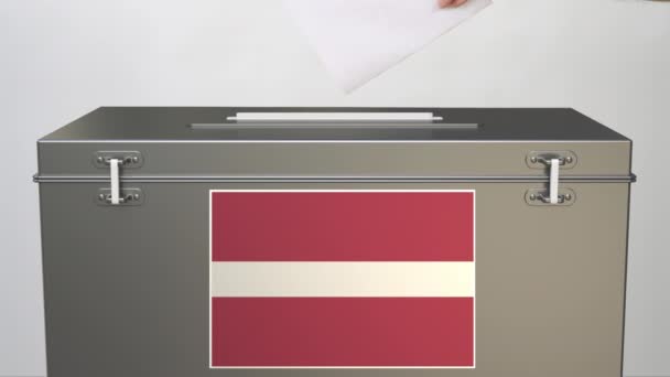 Hand putting paper ballot into ballot box with flag of Latvia. Election related clip — Stock Video