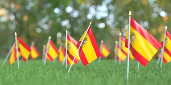 Wiele flag Hiszpanii w trawie. Święto narodowe związane z renderowaniem 3D — Zdjęcie stockowe