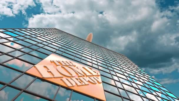 The Home Depot logo on a modern skyscraper reflecting clouds and flying airplane. Editorial conceptual 3d animation — Stock Video