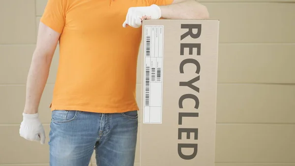 Trabalhador e caixa grande com texto RECYCLED nele — Fotografia de Stock