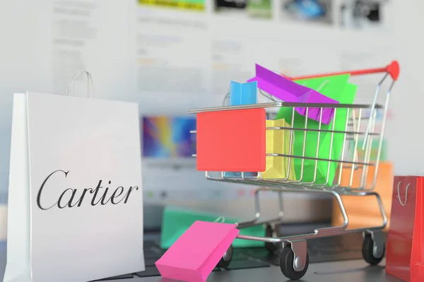 Papírová taška s logem Cartier a nákupním vozíkem na klávesnici notebooku. Editorial online nakupování související 3D vykreslování — Stock fotografie