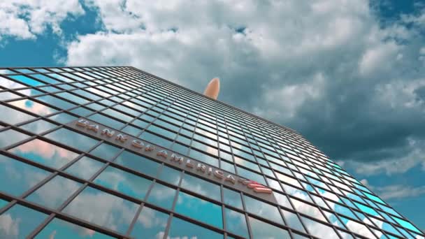 Логотип Bank of America на современном небоскребе, отражающем облака и летающий самолет. Редакционная концептуальная 3D анимация — стоковое видео