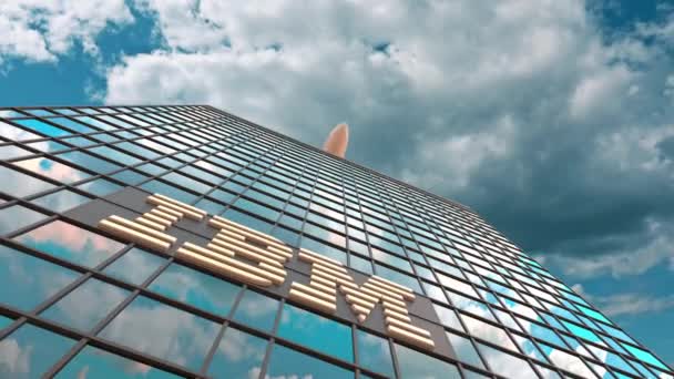 IBM logotyp på en modern skyskrapa reflekterande moln och flygande flygplan. Redaktionell konceptuell 3D-animation — Stockvideo