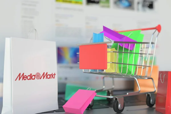 Saco de papel com logotipo Media Markt e carrinho de compras em um teclado de laptop. Editorial compras on-line relacionados 3D renderização — Fotografia de Stock