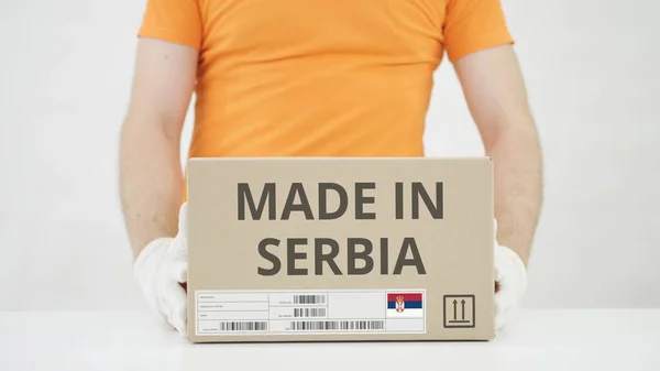 Parcela con texto MADE IN SERBIA y trabajador de almacén —  Fotos de Stock