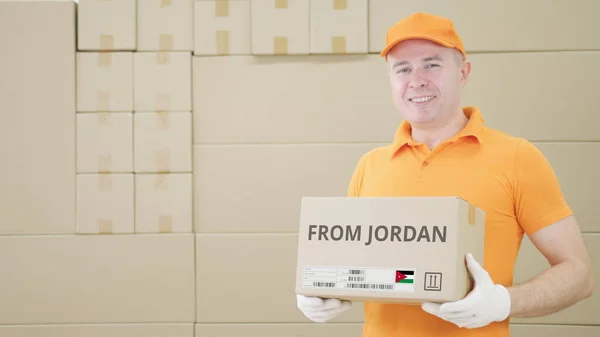 Trabajador de almacén sostiene el paquete con texto de JORDAN en él — Foto de Stock