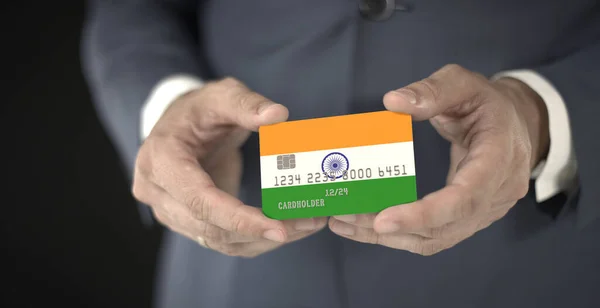 Empresário segurando cartão de banco de plástico com bandeira impressa da Índia, números fictícios — Fotografia de Stock