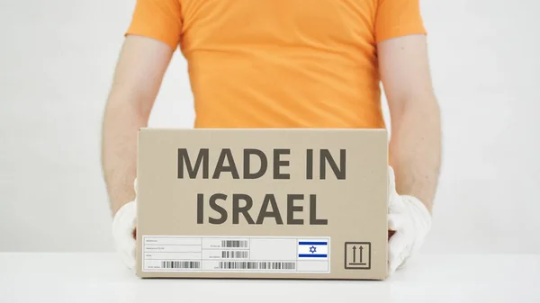 Kartong med MADE IN ISRAEL text som läggs på bordet — Stockfoto