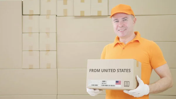 Man holding cardboard parcel with printed FROM UNITED STates text on it — Fotografia de Stock