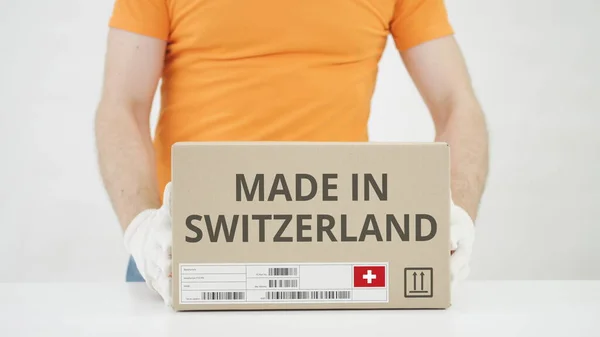 Recuadro con el texto MADE IN SWITZERLAND colocado sobre la mesa —  Fotos de Stock