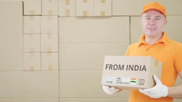 Warehouse worker holds parcel with FROM INDIA text on it — Stock Video