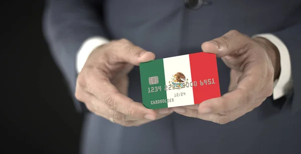 Empresário segurando cartão de banco de plástico com bandeira impressa do México, números fictícios — Fotografia de Stock