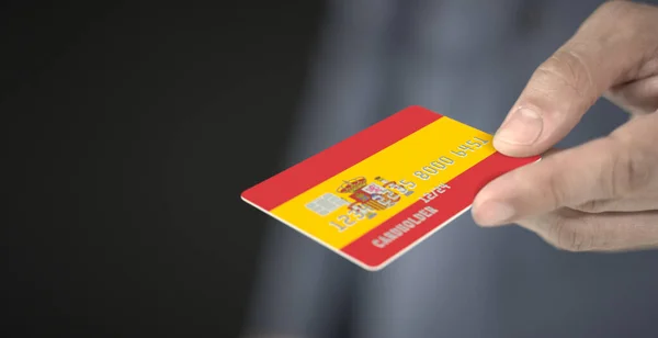 Man offers plastic bank card with printed flag of Spain, close-up shot. Fictional numbers — Stock Photo, Image