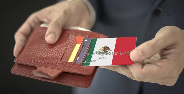 Muž vytáhne z peněženky plastovou bankovní kartu s vlajkou Mexika, fiktivní číslo karty — Stock fotografie