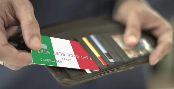 Puxando cartão bancário de plástico com bandeira da Itália para fora da carteira, número de cartão fictício — Fotografia de Stock