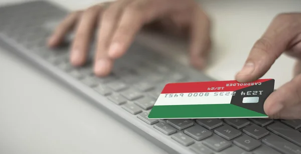 El hombre paga en línea con tarjeta bancaria de plástico con la bandera impresa de Kuwait. Números de ficción — Foto de Stock