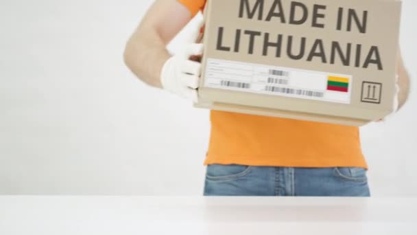 Karton med MADE IN LITHUANIA tekst lagt på bordet – Stock-video