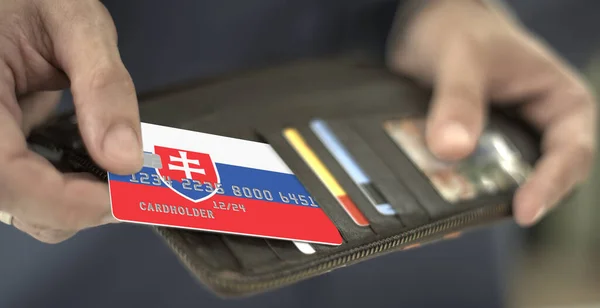 사람은 지갑에서 가상의 카드 번호인 슬로바키아 국기를 꺼내서 신용 카드를 뽑는다 — 스톡 사진