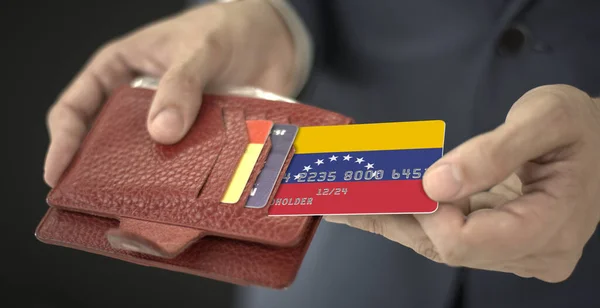 Muž vytáhne z peněženky plastovou bankovní kartu s vlajkou Venezuely, fiktivní číslo karty — Stock fotografie