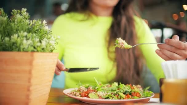 Невідома красива молода жінка їсть вегетаріанський салат у кафе. Концепція здорового харчування — стокове відео