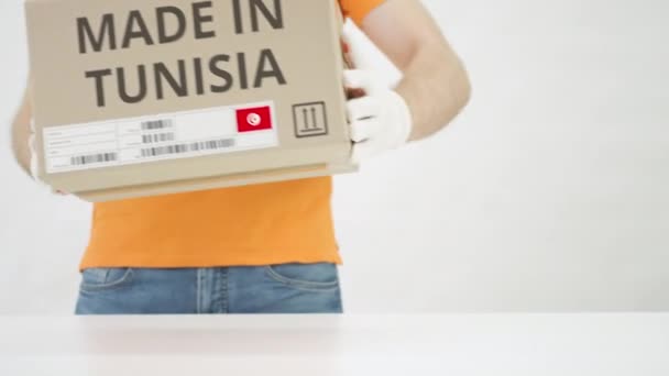 Box with MADE IN TUNISIA text being placed on the table — Stock Video