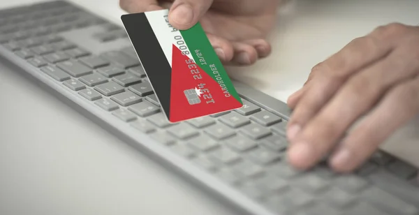 Hombre paga en línea con tarjeta de crédito con la bandera impresa de Jordania. Números de ficción — Foto de Stock