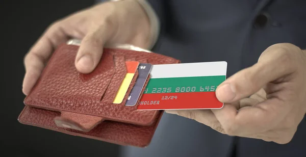 Бизнесмен вытаскивает пластиковую банковскую карту с флагом Болгарии из кошелька, вымышленный номер карты — стоковое фото