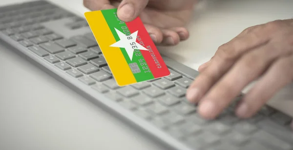 Människan betalar online med plastkort med tryckt flagga Myanmar. Fiktiva nummer — Stockfoto