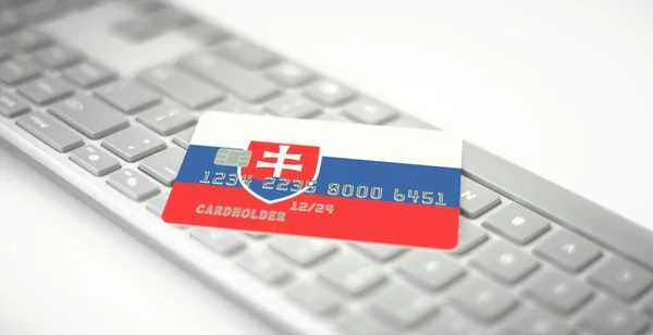 Plastová bankovní karta s vlajkou Slovenska na počítačové klávesnici. Fiktivní čísla — Stock fotografie
