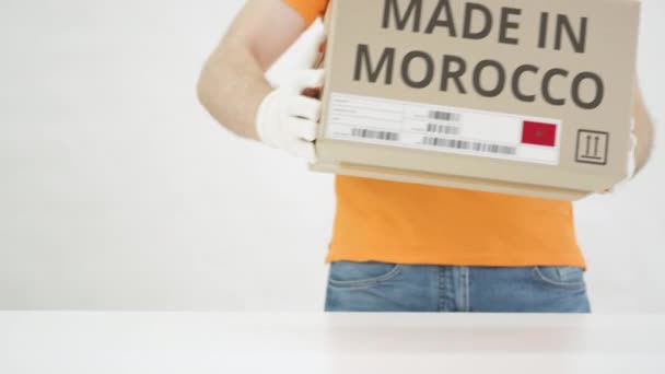 Kartonnen doos met MADE IN MOROCCO-tekst op tafel — Stockvideo