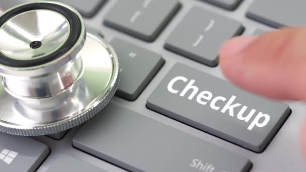 CHECKUP key being pressed on a computer keyboard near stethoscope — Stock Video