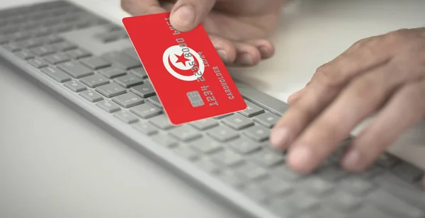 El hombre paga en línea con tarjeta bancaria de plástico con la bandera impresa de Túnez. Números de ficción — Foto de Stock