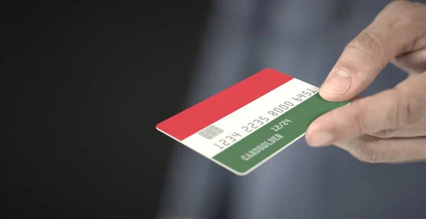 Man ofrece tarjeta de crédito con la bandera impresa de Hungría. Números de ficción — Foto de Stock