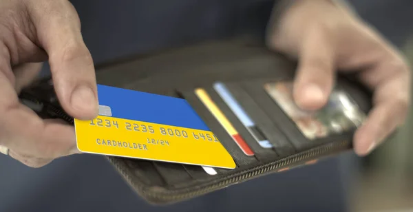 Επιχειρηματίας τραβά πλαστική τραπεζική κάρτα με σημαία της Ουκρανίας από το πορτοφόλι του, αριθμός πλασματικής κάρτας — Φωτογραφία Αρχείου