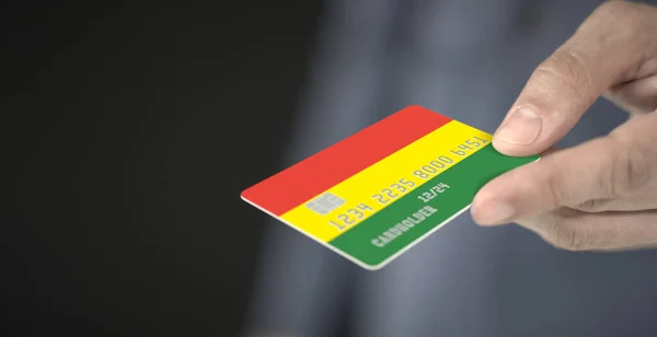 Ο άνθρωπος δίνει πλαστική τραπεζική κάρτα με τυπωμένη σημαία της Βολιβίας, κοντινό πλάνο. Φανταστικοί αριθμοί — Φωτογραφία Αρχείου