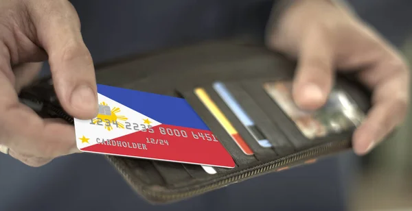 Pulling plastic bank card with flag of the Philippines out of the wallet, fictional card number — Stock Photo, Image