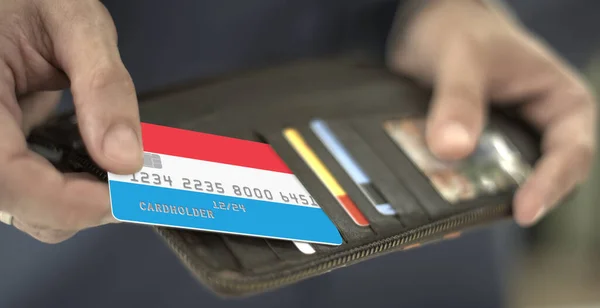 Τράβηξα πλαστική τραπεζική κάρτα με σημαία Λουξεμβούργου από το πορτοφόλι, αριθμός πλασματικής κάρτας — Φωτογραφία Αρχείου