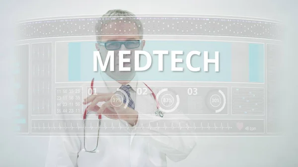 Doktor modern tıbbi ekran üzerinde MEDTECH sekmesine kayar — Stok fotoğraf