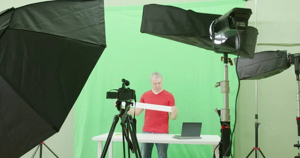 Blogger records a review video clip for social network on green screen background in the studio — Stock Photo, Image