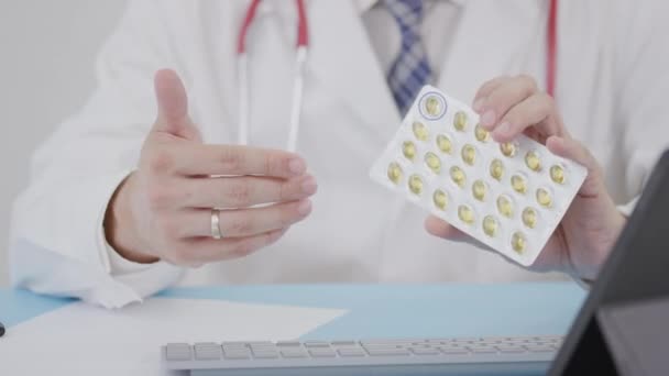 Doktorn håller en Cannabis softgels blisterförpackning i handen — Stockvideo