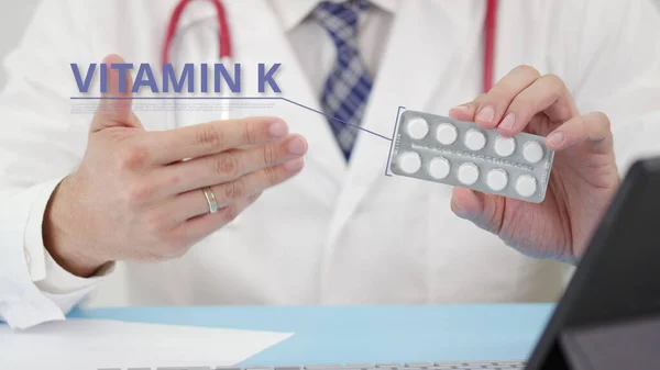 Vitamine k blisterverpakking met tabletten in de hand van de arts — Stockfoto