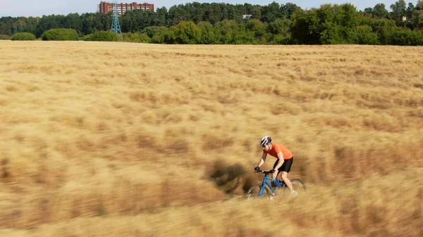 骑自行车的人沿着田野小径疾驰，俯瞰空中 — 图库照片