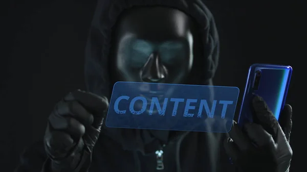 Hacker usando máscara preta puxa guia CONTEÚDO de um smartphone. Conceito de hacking — Fotografia de Stock