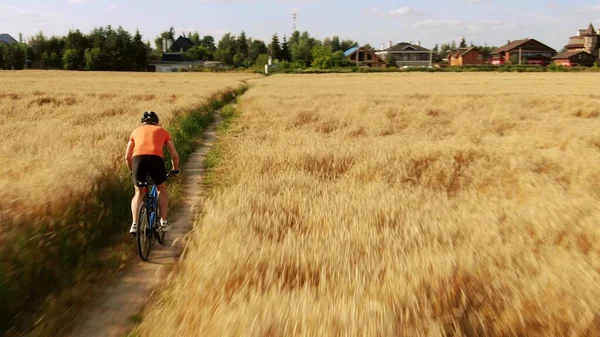 一个骑自行车的人在乡间田野小径上的低空跟踪镜头 — 图库照片