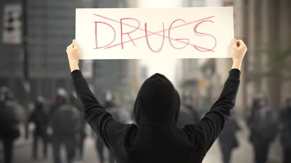 Manifestante vestido de negro sostiene un cartel sin texto de drogas — Foto de Stock