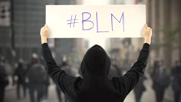 Διαδηλωτής φορώντας μαύρα κρατά πλακάτ με ετικέτα BLM ή Black Lives Matter — Φωτογραφία Αρχείου