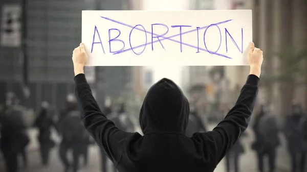 Manifestante vestido de negro sostiene un cartel sin texto ABORTION — Foto de Stock